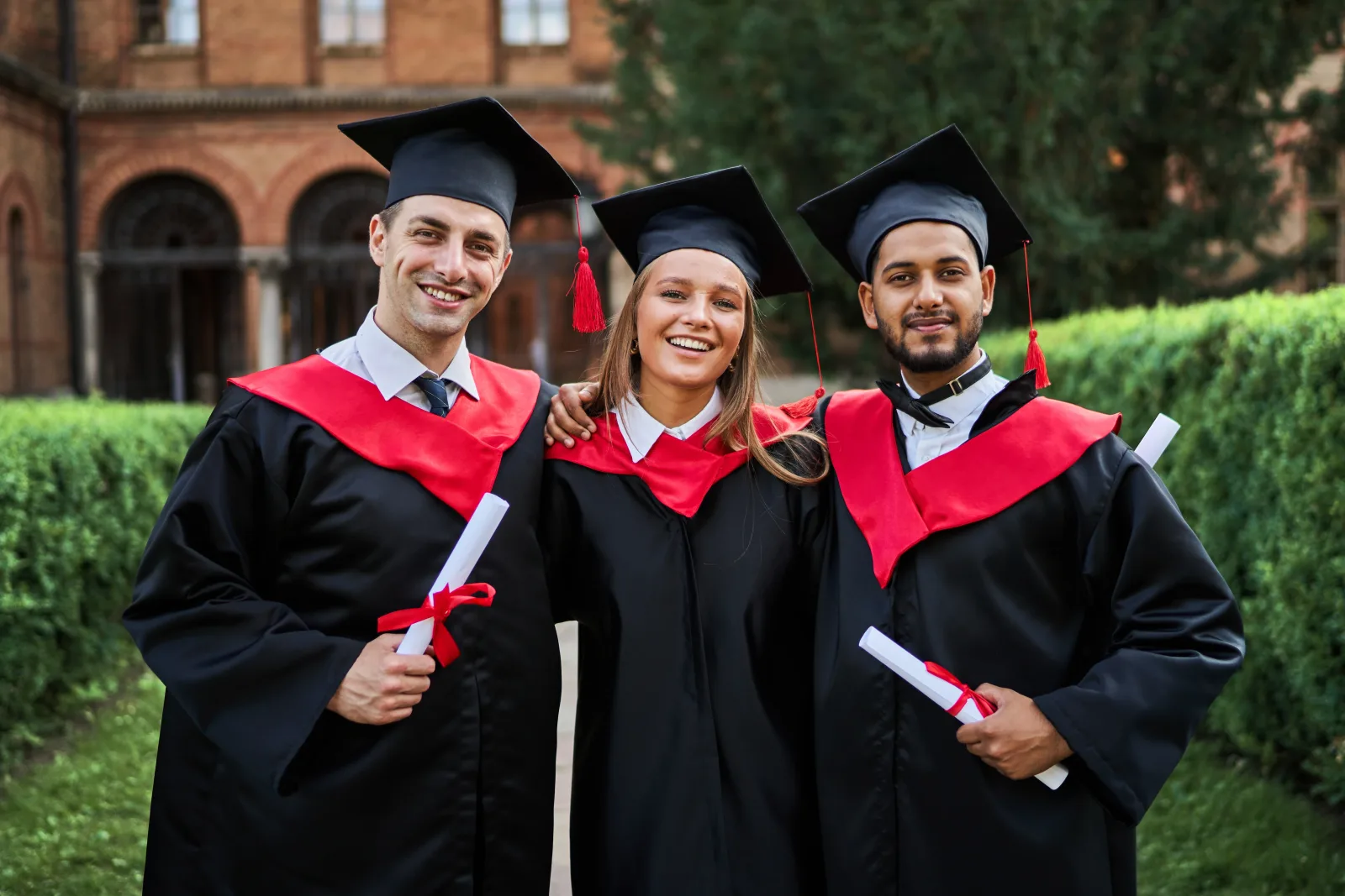 portrait-three-smiling-graduate-friends-graduation-robes-university-campus-with-diploma (2).webp